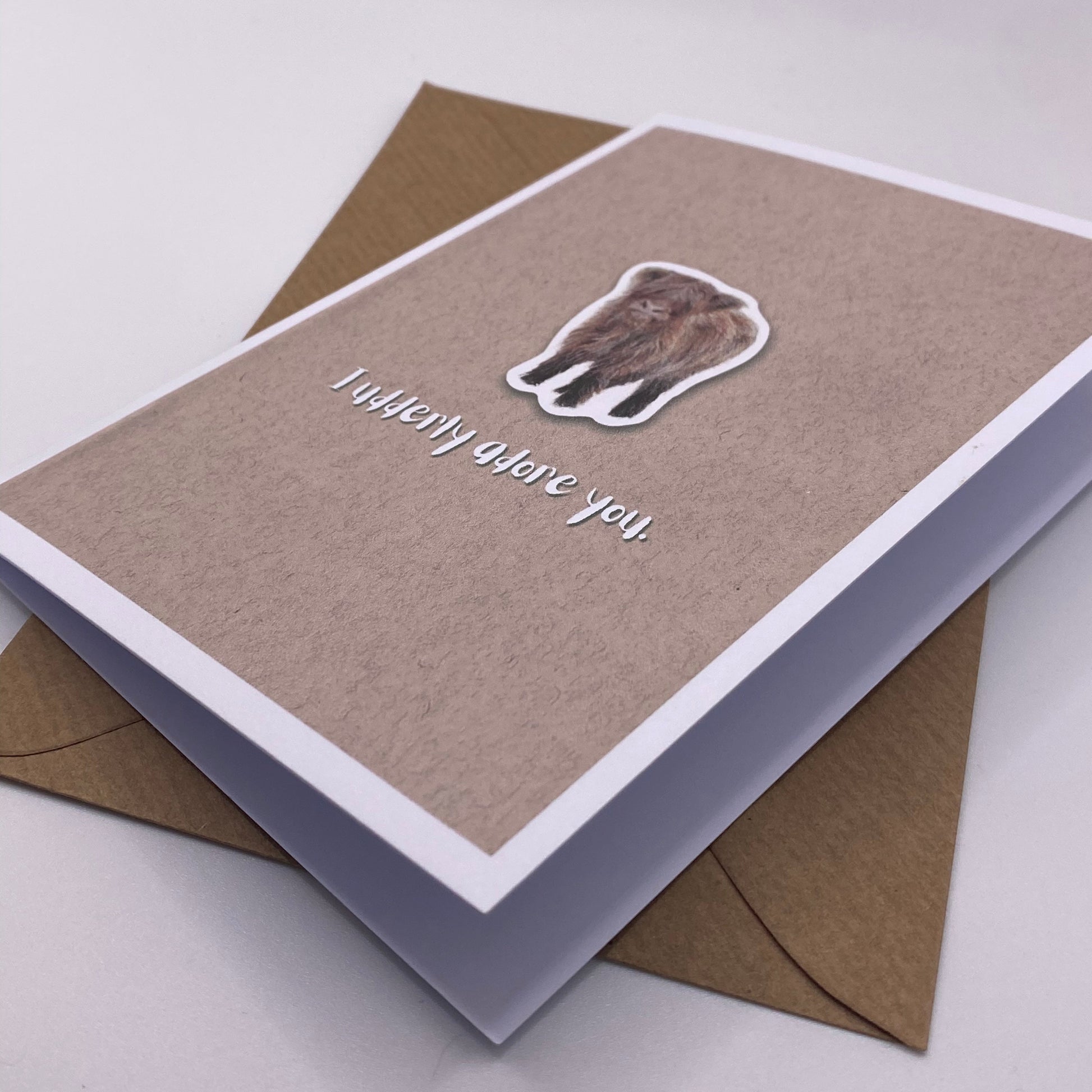 cute pun ainimal greetings card with highland cow calf saying "I udderly adore you" for Valentine's day