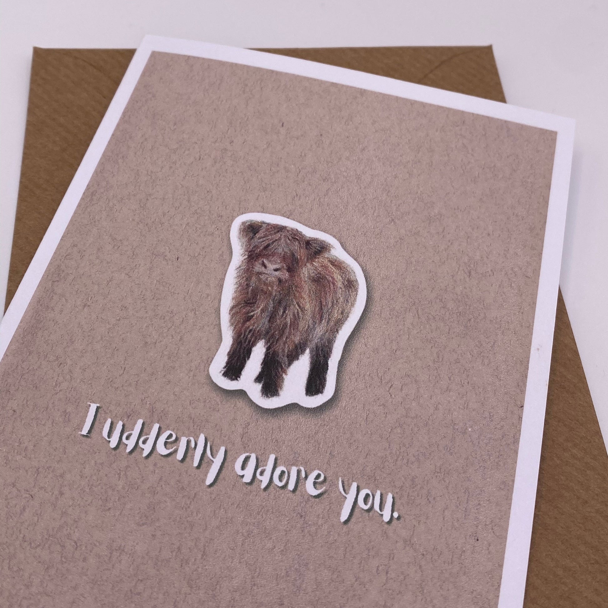 cute pun ainimal greetings card with highland cow calf saying "I udderly adore you" for Valentine's day